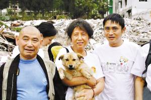 这只狗狗就是“前进”，左边是将它养大的彭州银厂沟景区佛应寺住持智富。(图片由“爱之家”提供)